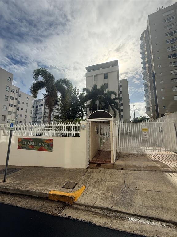 An exterior view of the El Avellano apartment complex entrance with palm trees and fencing — 559 CUEVILLA UNIT 1 B, SAN JUAN, PR