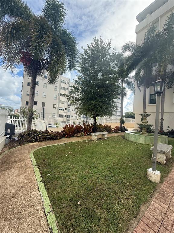 A small courtyard features a grassy lawn, a tiered fountain, and a stone bench — 559 CUEVILLA UNIT 1 B, SAN JUAN, PR