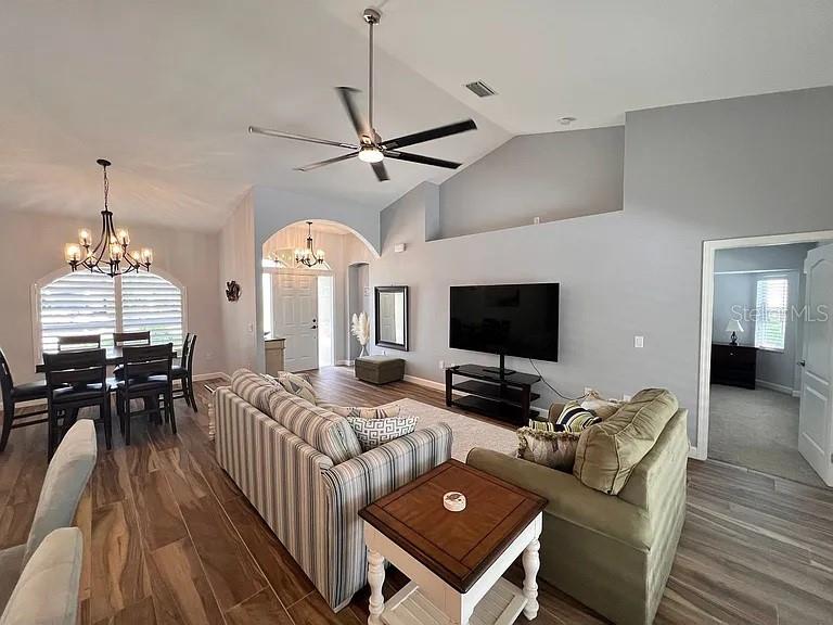 A living room features a vaulted ceiling, a ceiling fan, and a large television — 5530 ALMAR DRIVE, PUNTA GORDA, FL
