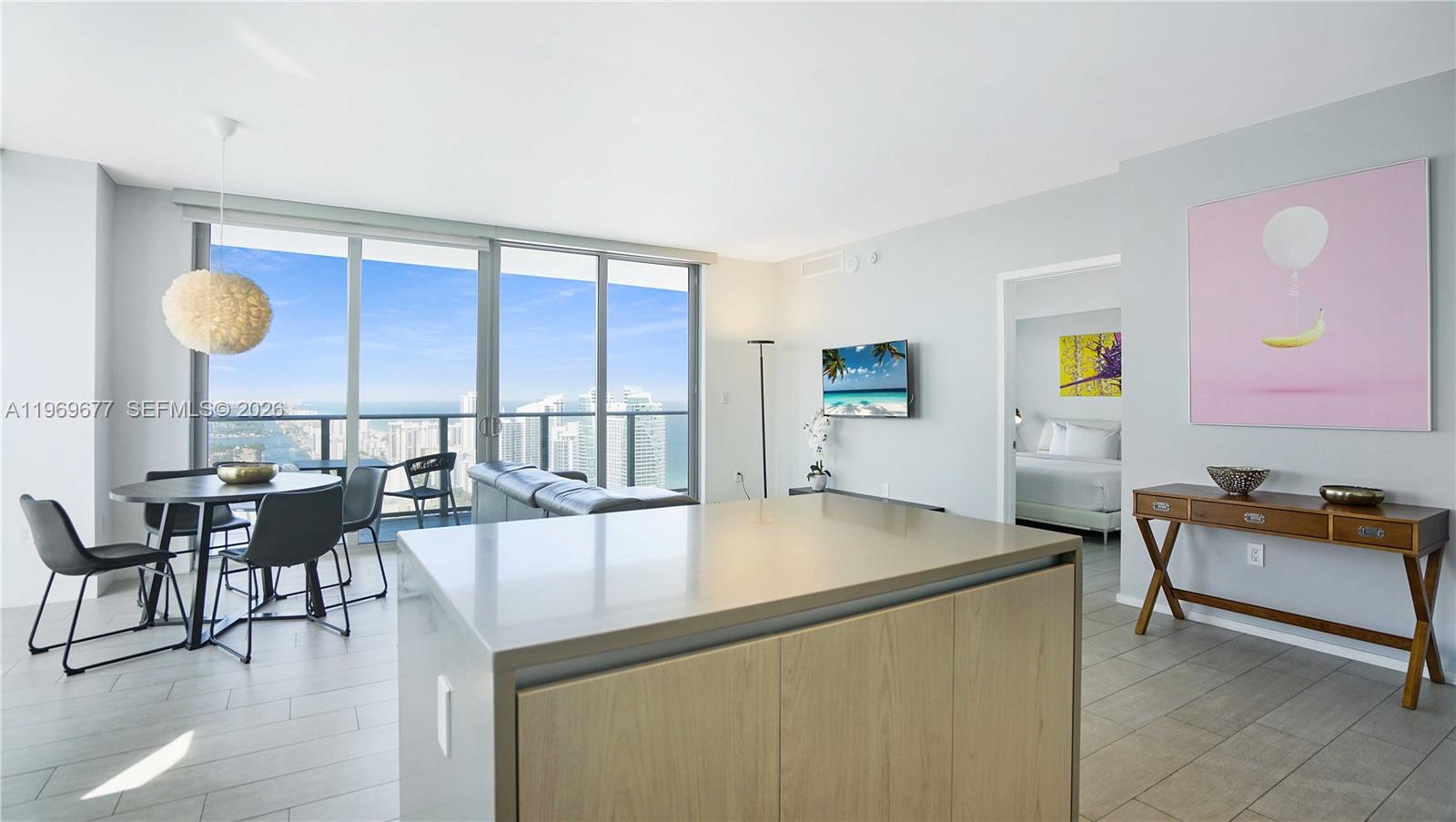 A modern apartment features an open kitchen island, dining area, and floor-to-ceiling ocean views — 4010 S Ocean Dr # T4002, Hollywood FL 33019, HOLLYWOOD, FL