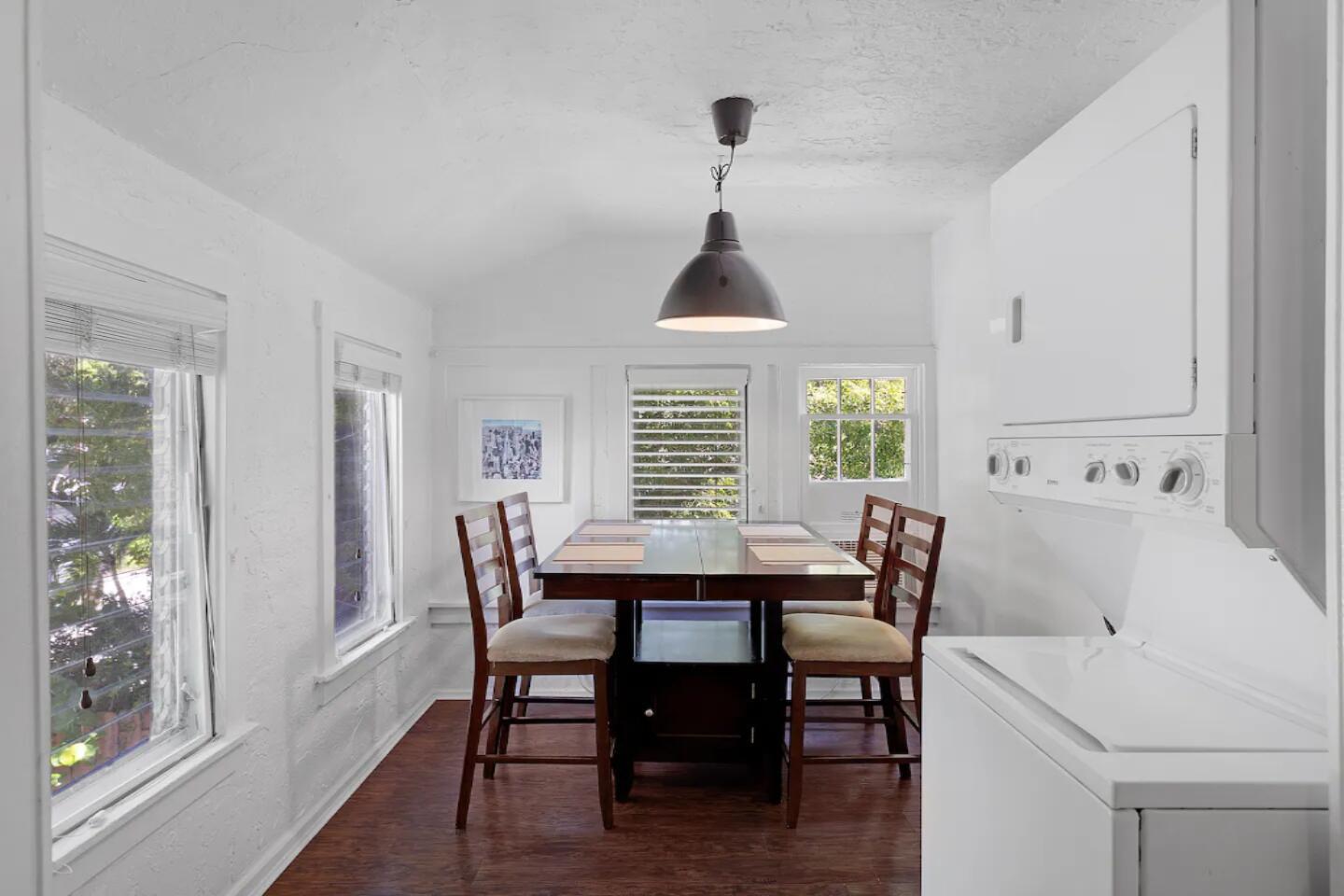 A dining area with a dark wood table and chairs next to a laundry unit — 204 S M Street, FL 33460, FL