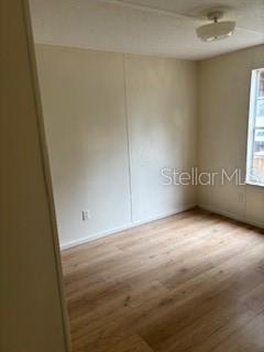 An empty room features light-colored walls, wood-look flooring, and a single window — 175 PIEDMONT COURT, MELROSE, FL