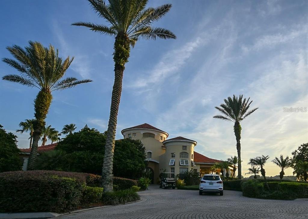 A white SUV is parked in front of a Mediterranean-style building with palm trees — 7270 WESTPOINTE BOULEVARD UNIT 920, ORLANDO, FL