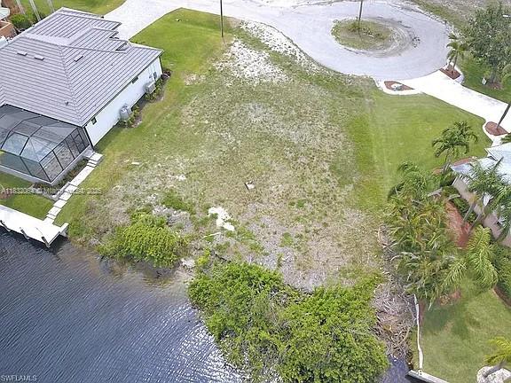 An aerial view shows a vacant waterfront lot situated between two houses and a cul-de-sac — 1253 NW 39th Ave, Cape Coral FL 33993, CAPE CORAL, FL