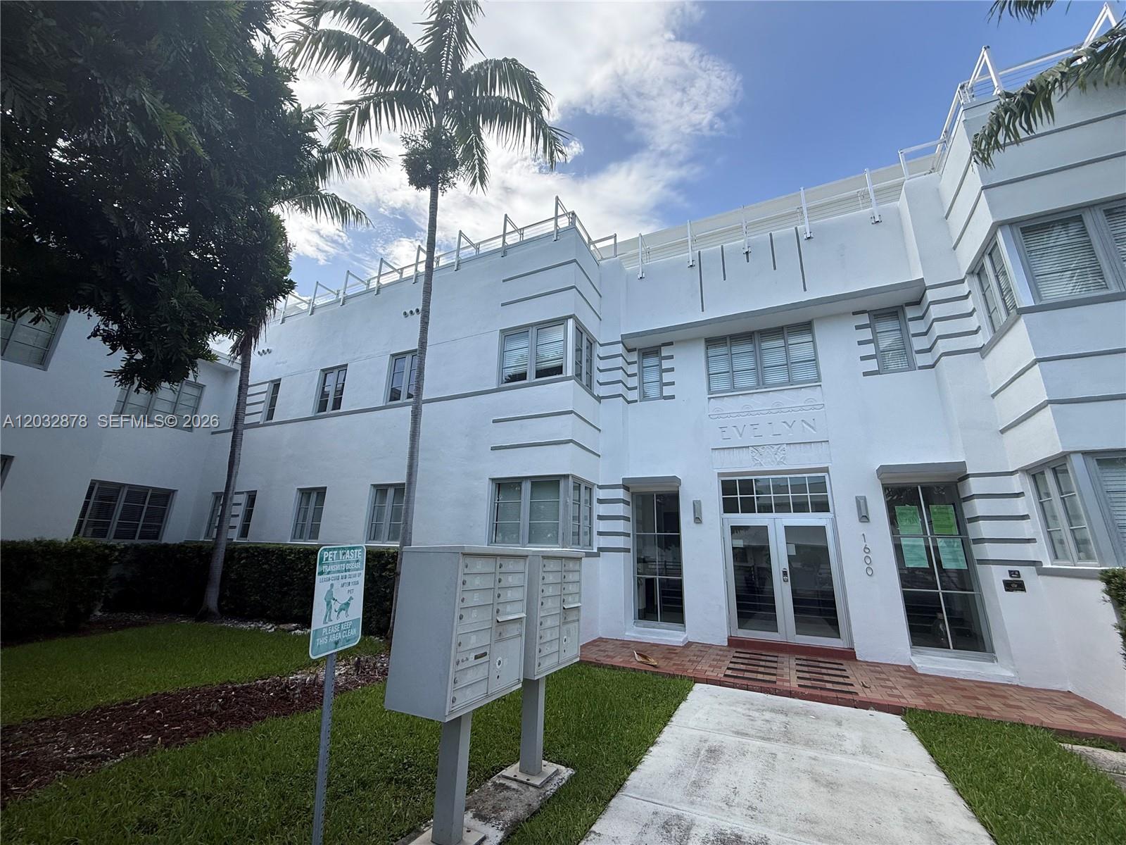 The exterior of a white Art Deco apartment building features a central entrance and mailboxes — 1600 Euclid Ave # 102, Miami Beach FL 33139, MIAMI BEACH, FL