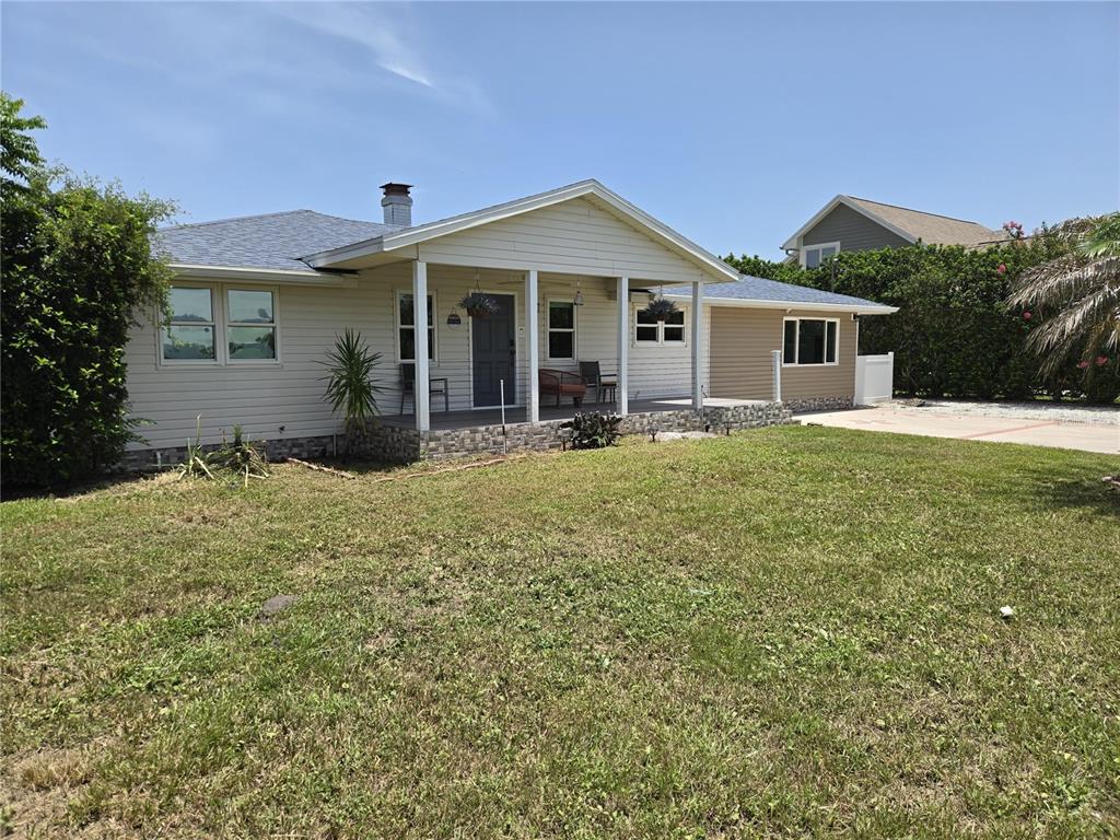 A single-story house with light siding, a covered front porch, and a grassy yard — 2625 HARRIS BOULEVARD, KISSIMMEE, FL