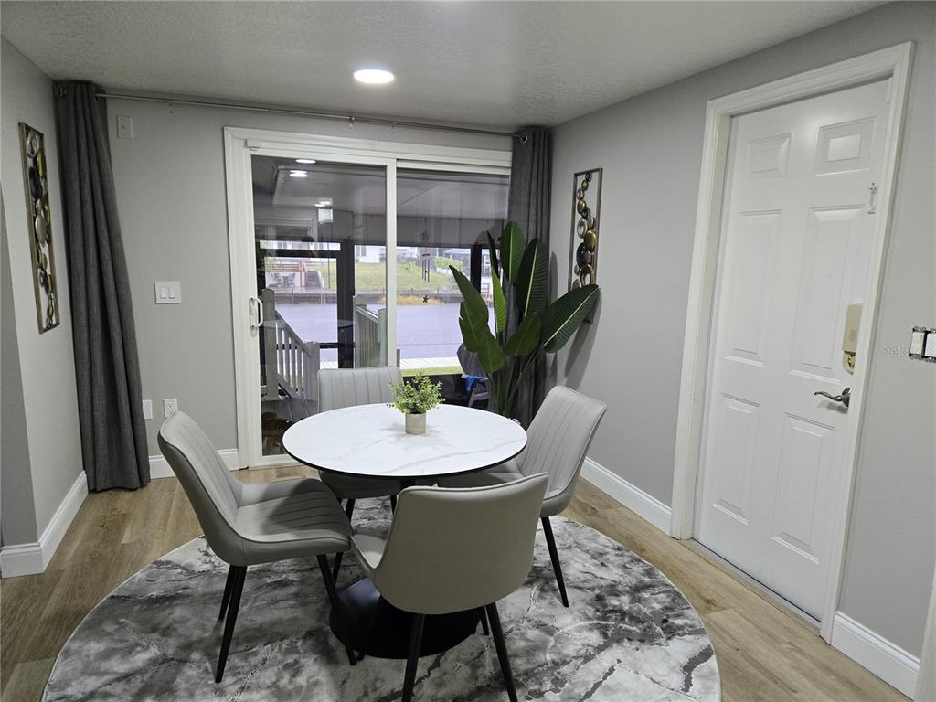 A dining area features a round marble table, four grey chairs, and a sliding glass door — 2625 HARRIS BOULEVARD, KISSIMMEE, FL