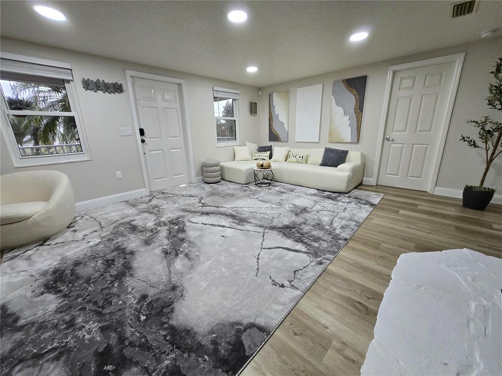 A living room features a large marble-patterned rug, a white sectional sofa, and light-colored flooring — 2625 HARRIS BOULEVARD, KISSIMMEE, FL
