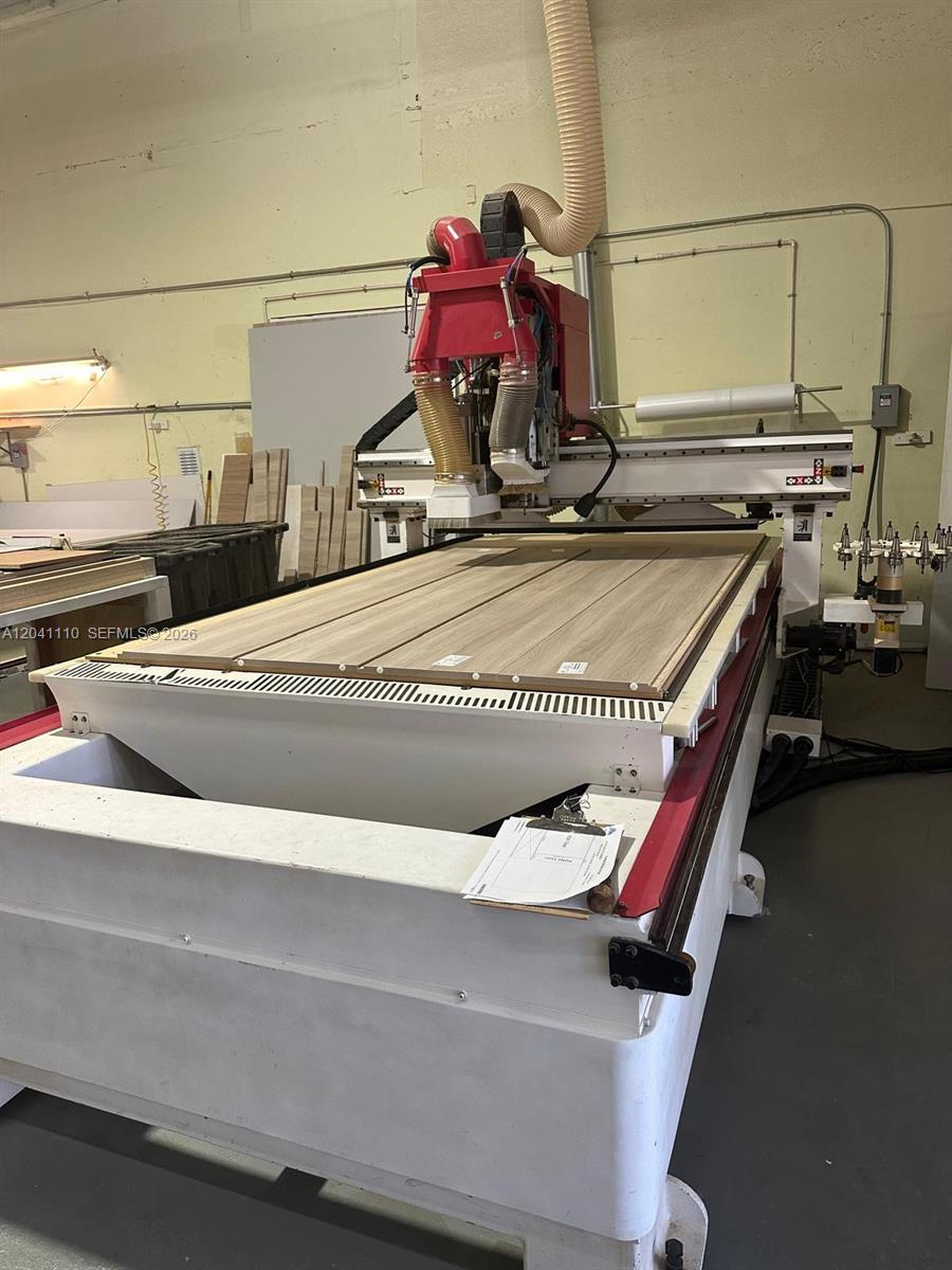 A large industrial CNC router machine sits in a workshop with wood panels on its bed — Cabinet Manufacturing, Hialeah FL 33016, HIALEAH, FL