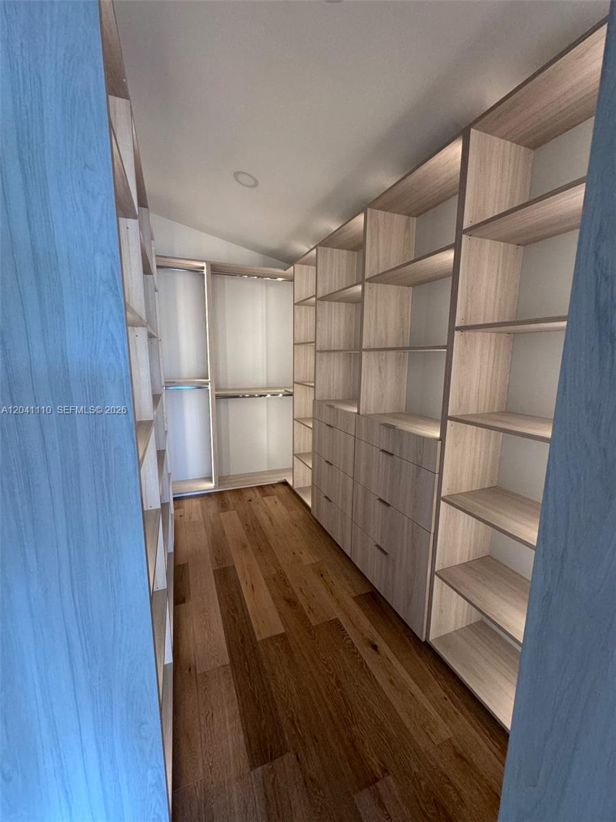 A walk-in closet features light wood shelving, built-in drawers, and hardwood flooring — Cabinet Manufacturing, Hialeah FL 33016, HIALEAH, FL