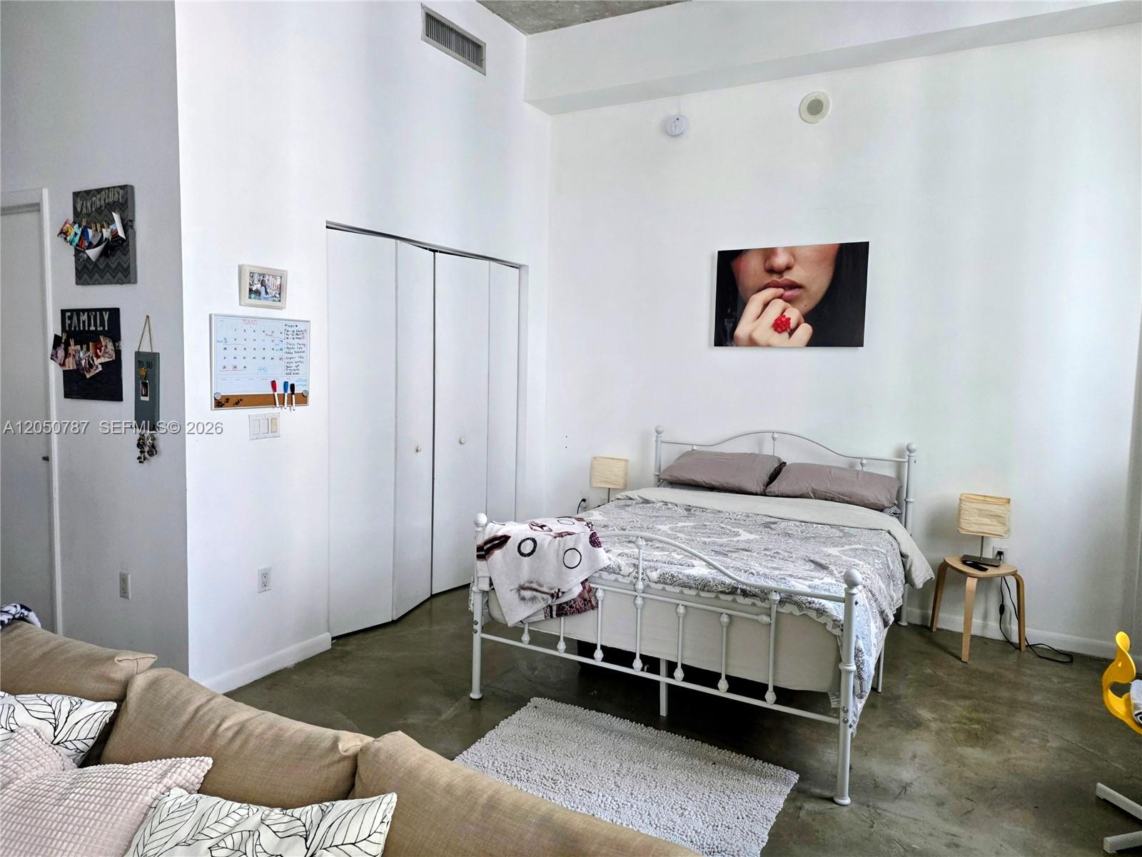 A bedroom features a white metal bed frame, concrete floors, and a large wall print — 234 NE 3rd St, Miami FL 33132, MIAMI, FL
