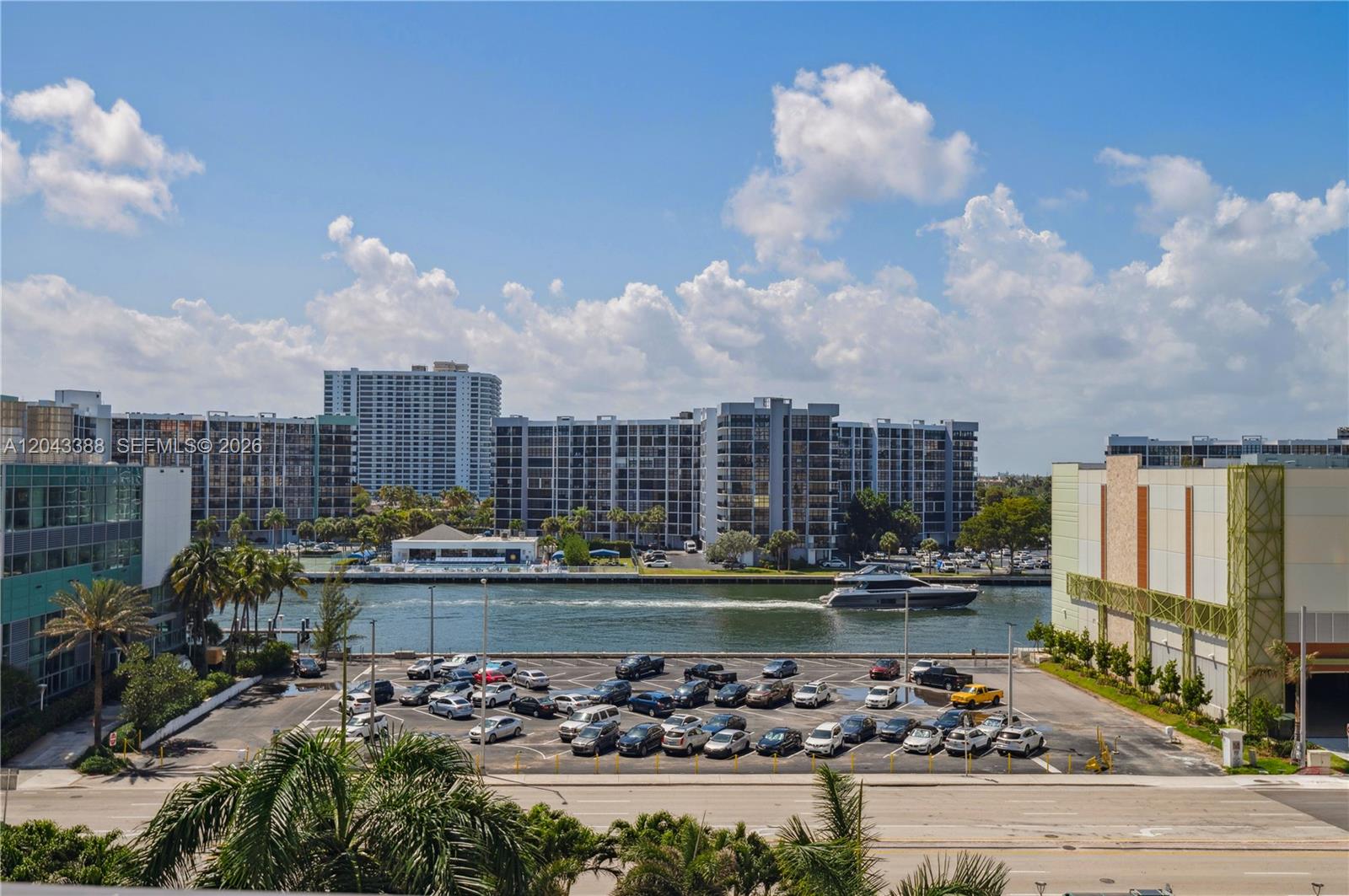 An elevated view shows a parking lot, a waterway with a boat, and apartment buildings — 3505 S OCEAN DR # 604, Hollywood FL 33019, HOLLYWOOD, FL