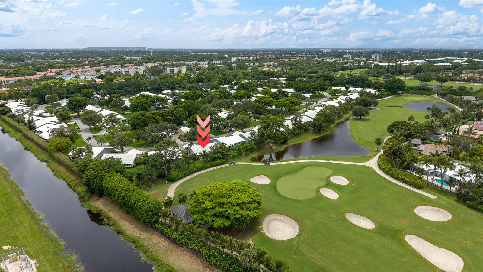 An aerial view shows a residential neighborhood bordering a golf course and a canal — 5557 N Cameo Drive N, Boca Raton FL 33433, BOCA RATON, FL
