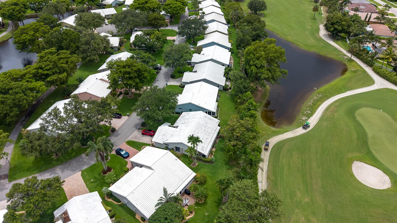 An aerial view shows a row of houses with white roofs bordering a golf course — 5557 N Cameo Drive N, Boca Raton FL 33433, BOCA RATON, FL