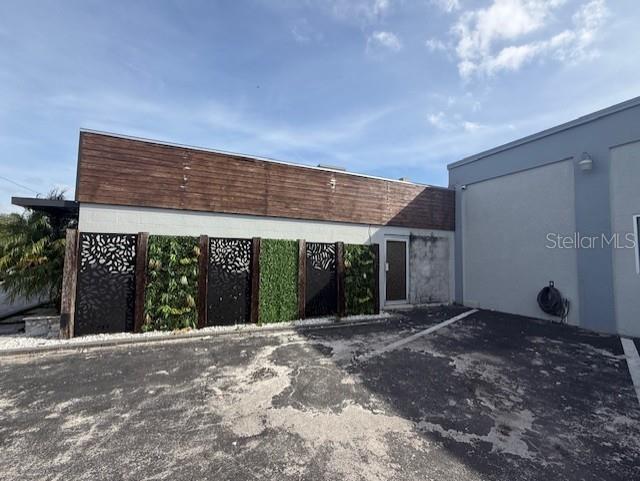 The exterior of a building features a wood-paneled upper wall and decorative privacy screens — 3852 L B MCLEOD ROAD, ORLANDO, FL