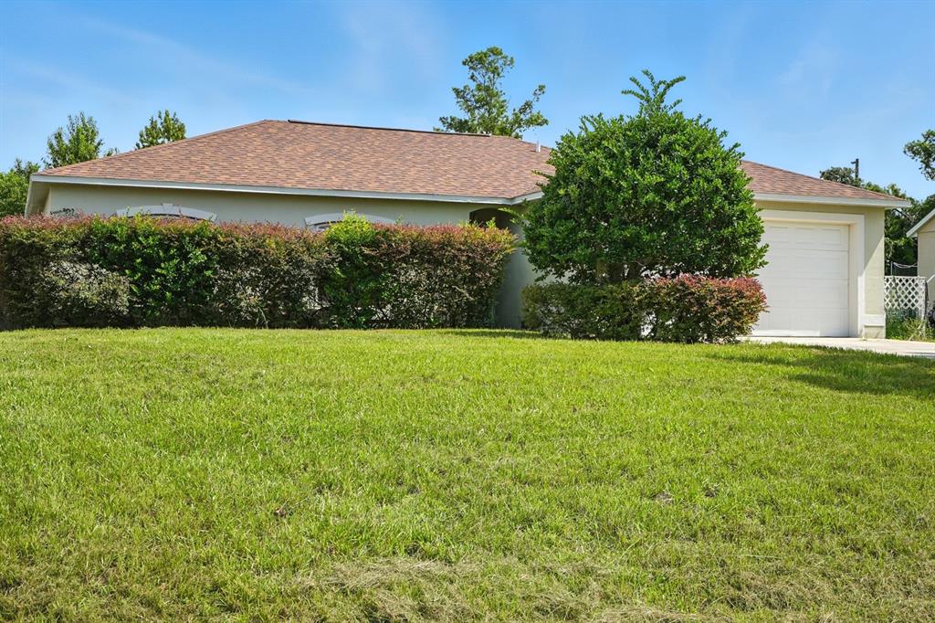 A single-story house with a tan exterior, a brown shingled roof, and a front lawn — 3154 LYNNHAVEN STREET, DELTONA, FL