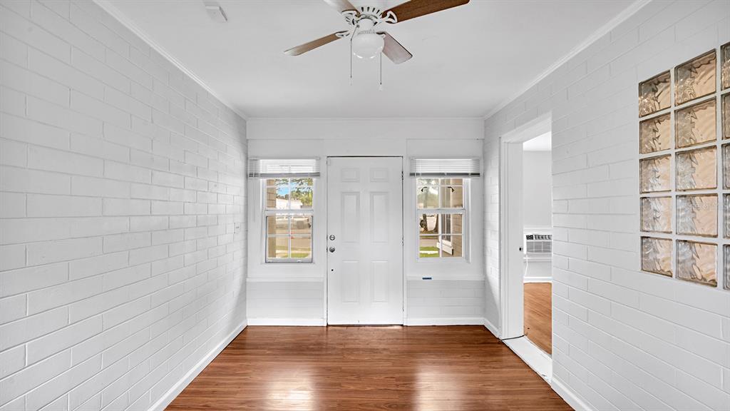 A room with white painted brick walls, wood-look flooring, a ceiling fan, and glass blocks — 1810 HILLCREST STREET, ORLANDO, FL