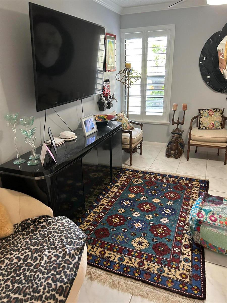 A living room features a black media console, a patterned area rug, and two chairs — 10271 N Circle Lake Drive, Boynton Beach FL 33437, BOYNTON BEACH, FL