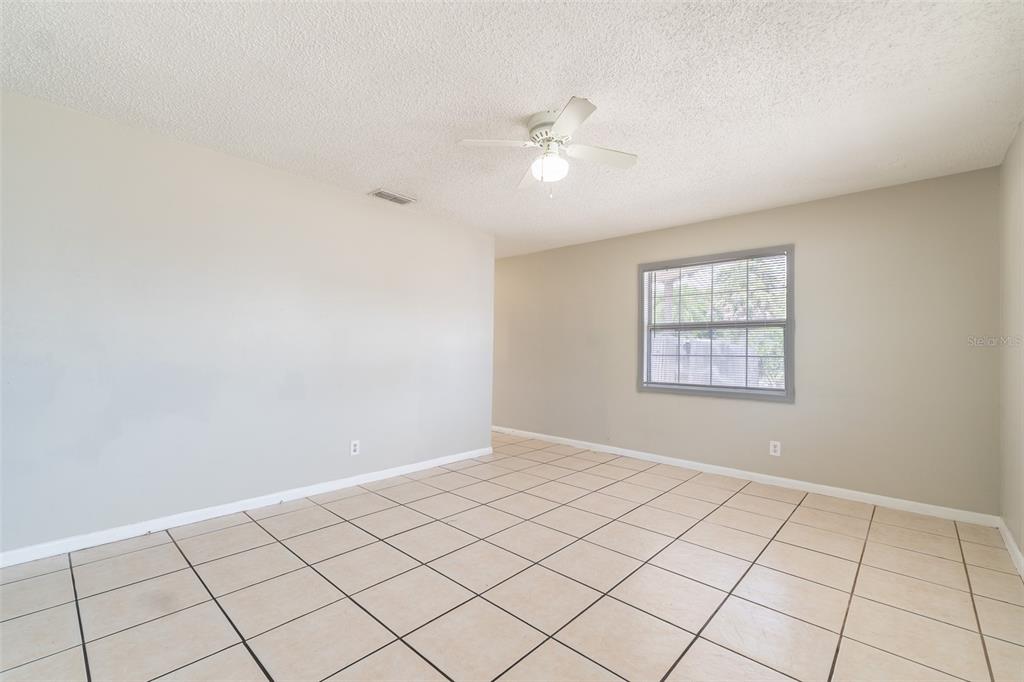 A room with light-colored walls, a ceiling fan, and beige tiled flooring — 6001 CRESTRIDGE ROAD, TAMPA, FL