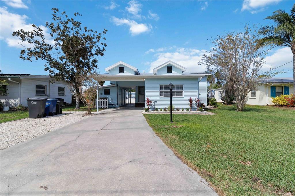 A light blue single-story house with a carport and a concrete driveway — 607 MANATEE AVENUE, ELLENTON, FL