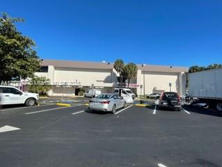 A parking lot in front of a multi-story commercial building under a clear blue sky — 900 NE 125th St, North Miami FL 33161, NORTH MIAMI, FL