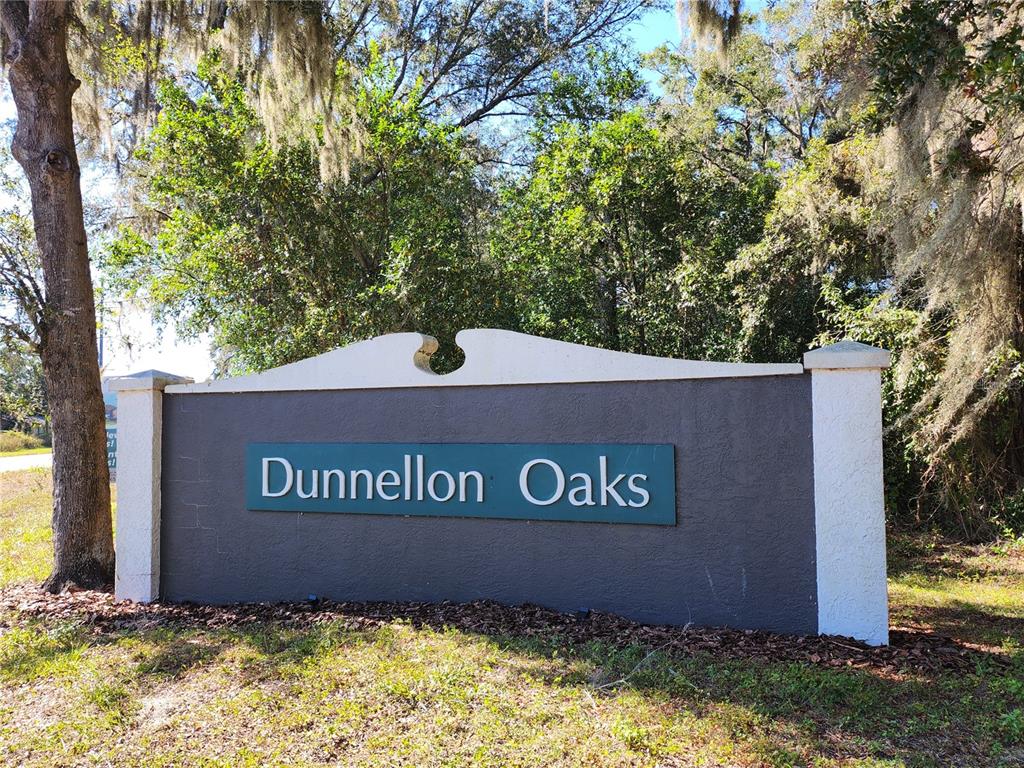 A gray monument sign with the text Dunnellon Oaks stands outdoors near trees — TBD SW 175 COURT, DUNNELLON, FL