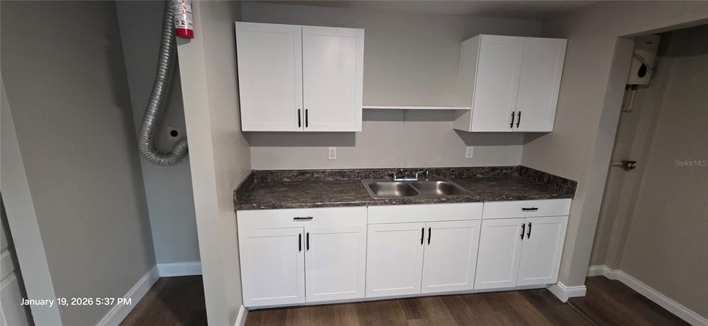 A kitchen area features white cabinets, a dark laminate countertop, and a double-basin sink — 603 W 27TH AVENUE, BRADENTON, FL