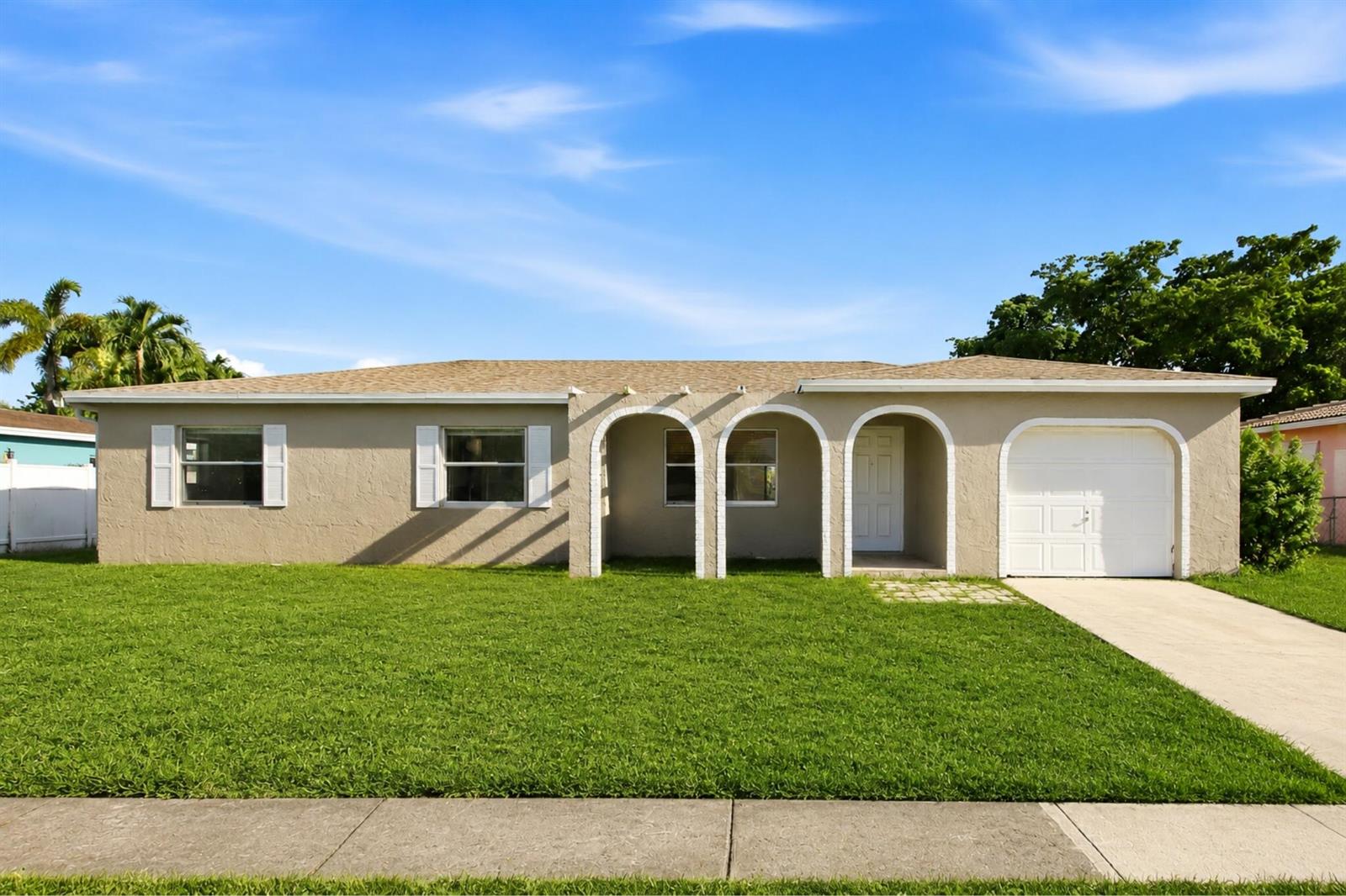 A single-story house with a tan exterior, arched entryway, and an attached one-car garage — 10894 Granite Street, Boca Raton FL 33428, BOCA RATON, FL