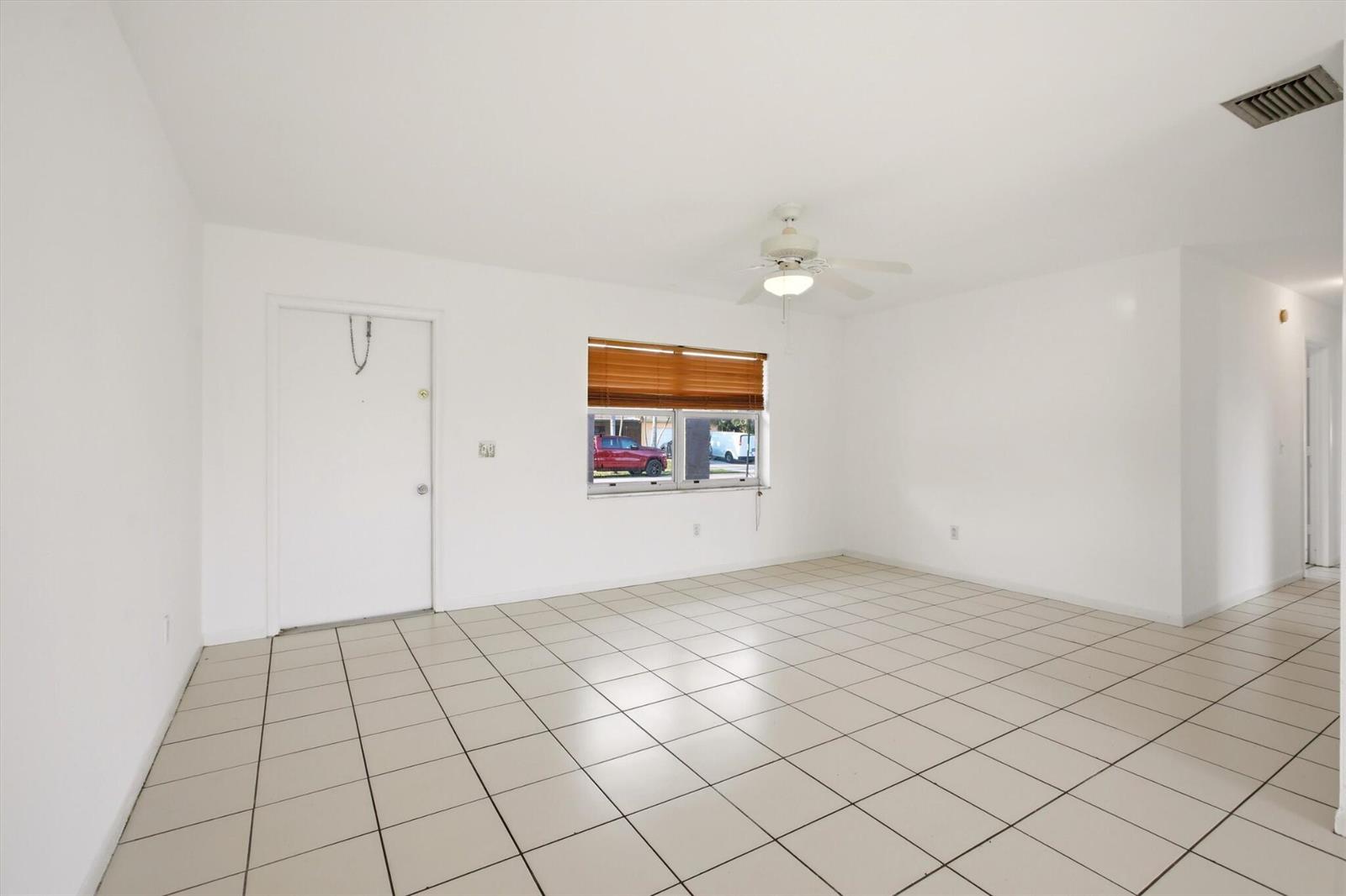 An empty room with white walls, light-colored floor tiles, a ceiling fan, and a window — 10894 Granite Street, Boca Raton FL 33428, BOCA RATON, FL