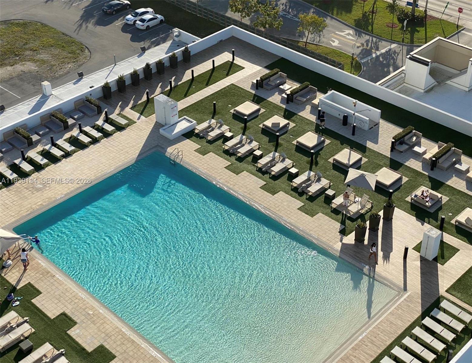 An elevated view of a swimming pool surrounded by lounge chairs and artificial turf — 5252 NW 85th Ave # 1109, Doral FL 33166, DORAL, FL