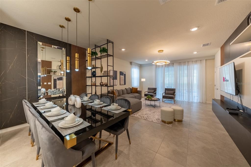 A modern open-concept living and dining area features a black table, gray chairs, and shelving — 4470 KAIPO ROAD, DAVENPORT, FL