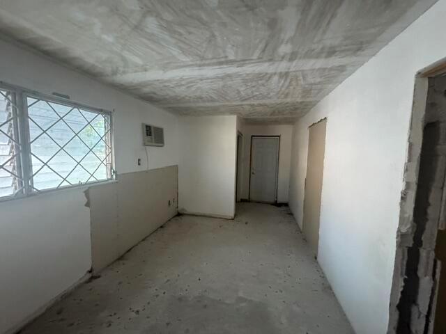 An unfinished room with white walls, a concrete floor, and a window with security bars — 1781 NW 6th Terrace, Pompano Beach FL 33060, POMPANO BEACH, FL