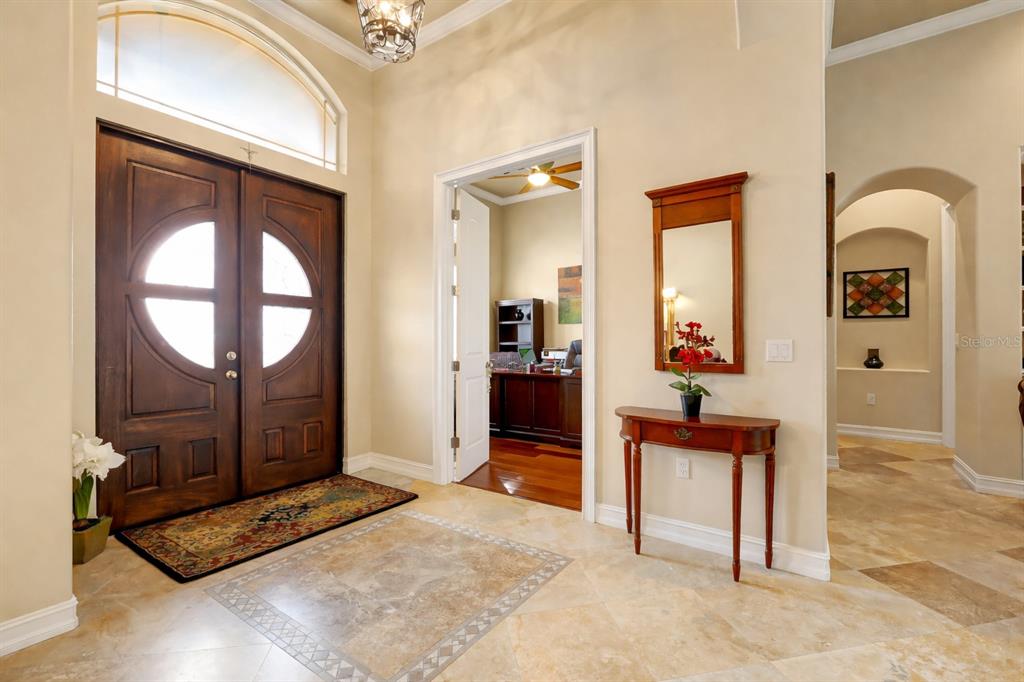 A covered outdoor patio features a stone fireplace, a television, and blue cushioned wicker furniture — 12012 RAMBLING OAK BOULEVARD, ORLANDO, FL