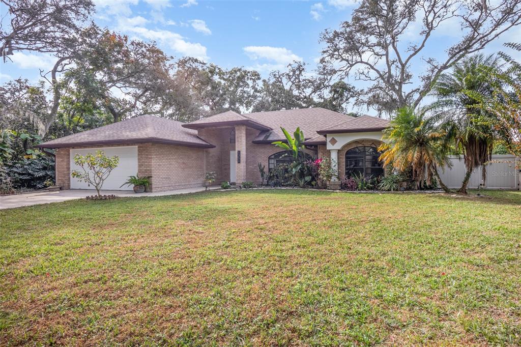 A single-story brick house with a two-car garage and a large front lawn — 1356 CANARY DRIVE, DELAND, FL