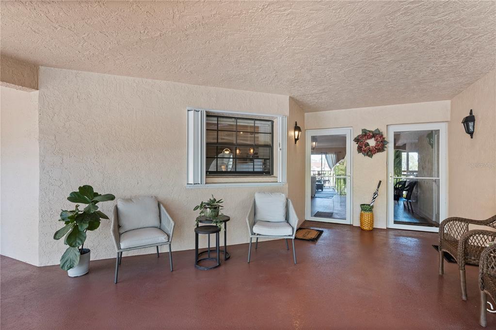 An aerial view shows a swimming pool, shuffleboard courts, and a clubhouse near a pond — 23465 HARBORVIEW ROAD UNIT 724, PUNTA GORDA, FL