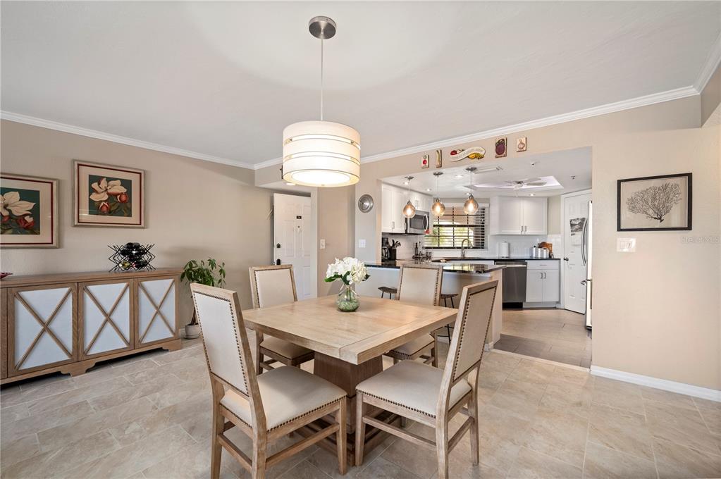 A covered patio features a textured beige wall, two gray chairs, and two glass doors — 23465 HARBORVIEW ROAD UNIT 724, PUNTA GORDA, FL