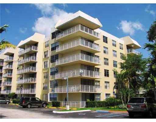 A multi-story apartment building with beige exterior walls and stacked balconies under a blue sky — 13100 SW 92nd Ave # 112, Miami FL 33176, MIAMI, FL