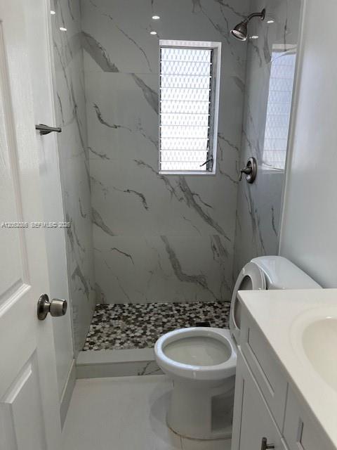 A bathroom features a walk-in shower with marble-look tile, a pebble floor, and a toilet — 922 NW 2nd St # 4, Miami FL 33128, MIAMI, FL