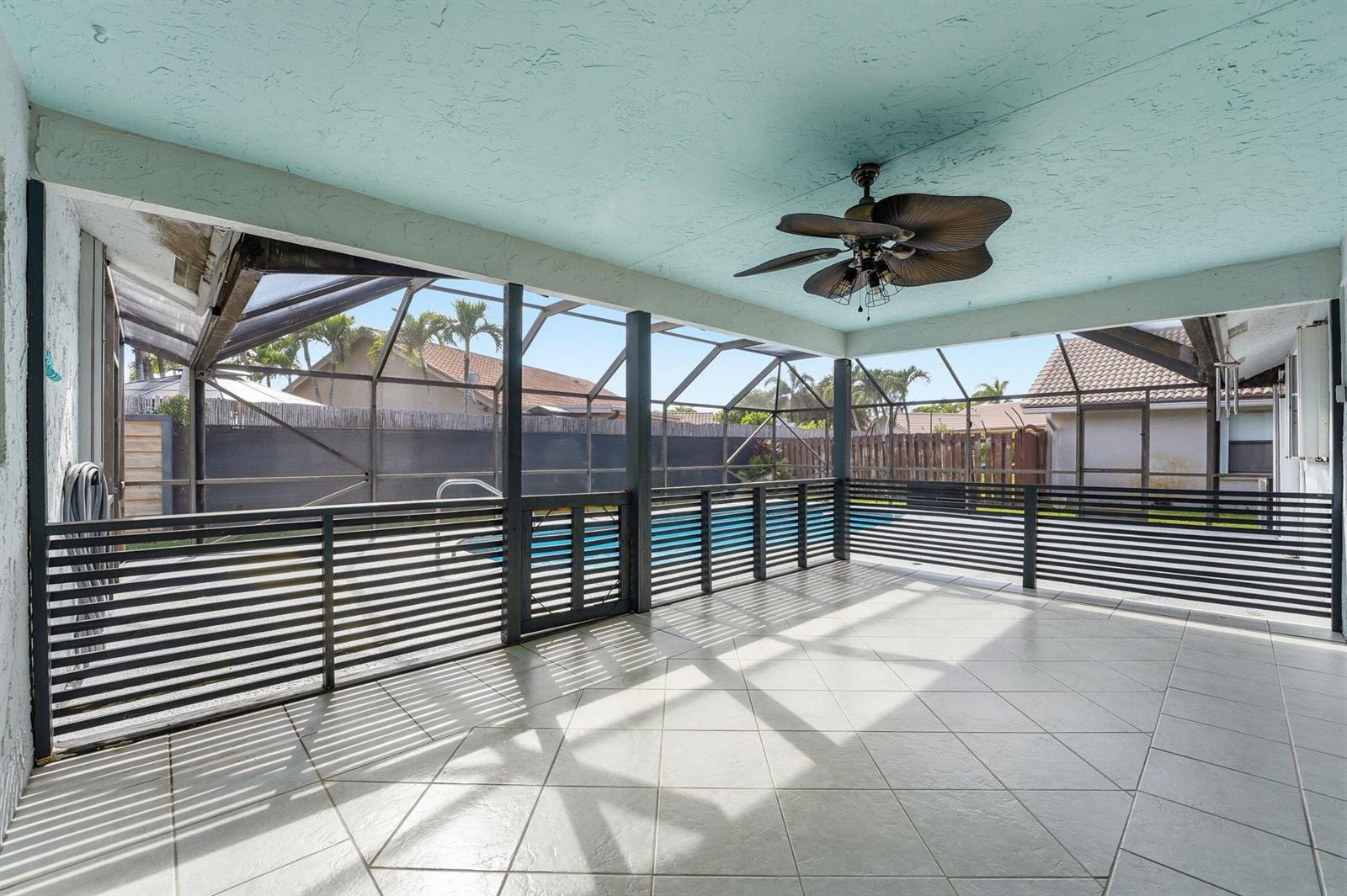 A covered patio with tiled flooring, a ceiling fan, and a screened-in pool area — 9284 Laurel Green Drive, Boynton Beach FL 33437, BOYNTON BEACH, FL