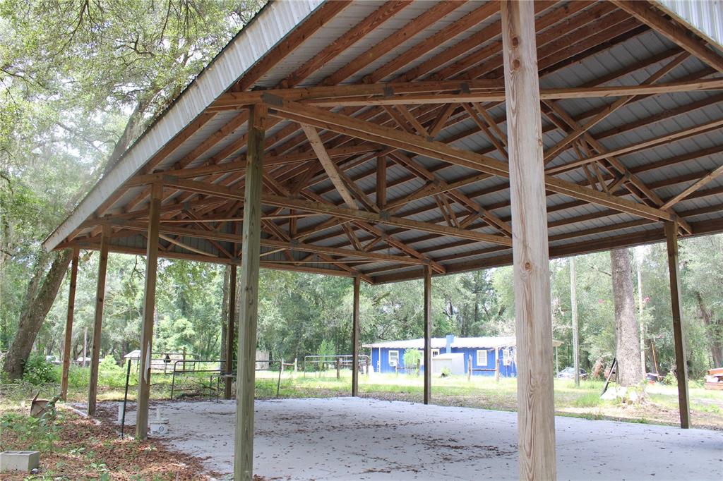 A large, open-sided pole barn with a metal roof stands over a concrete slab — 29160 SE 150TH STREET, ALTOONA, FL