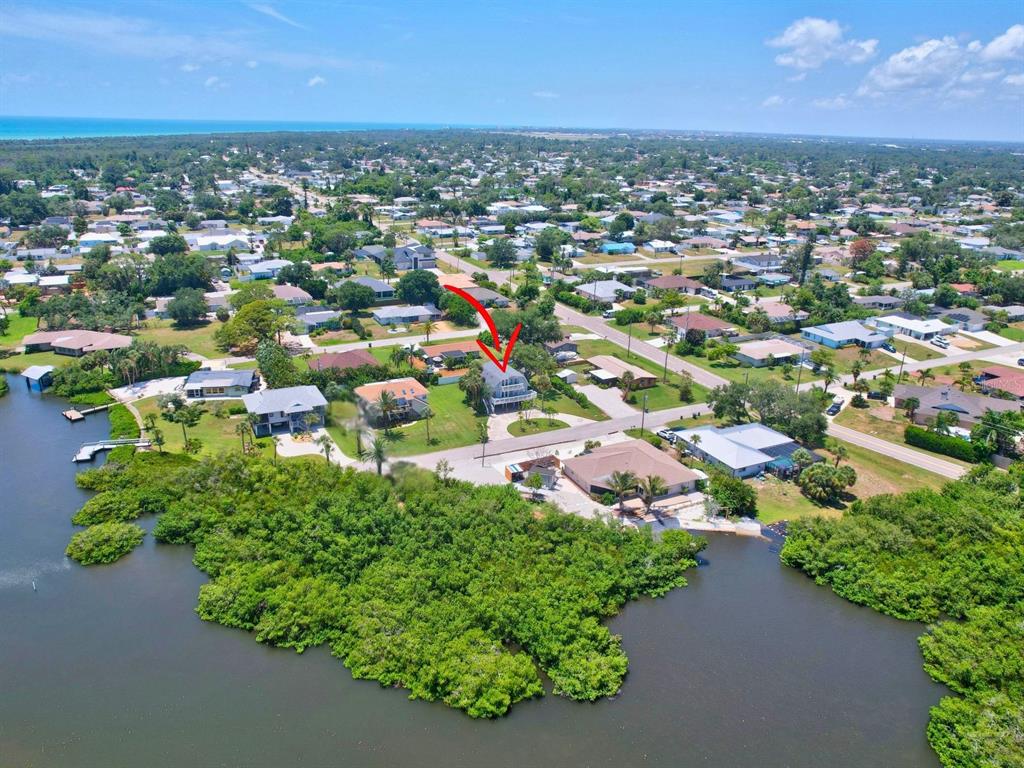 An aerial view shows a coastal neighborhood with a red arrow pointing to a house — 1194 LINDEN ROAD, VENICE, FL