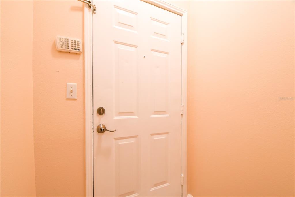 A white interior door with a security keypad mounted on the adjacent peach-colored wall — 14214 FREDRICKSBURG DRIVE UNIT 108, ORLANDO, FL