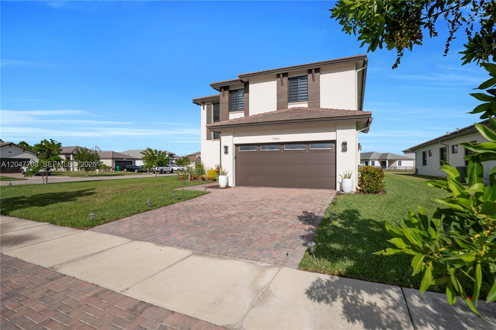 A two-story house with a brown garage door and a brick paver driveway — 5206 Karlia Dr, Ave Maria FL 34142, AVE MARIA, FL
