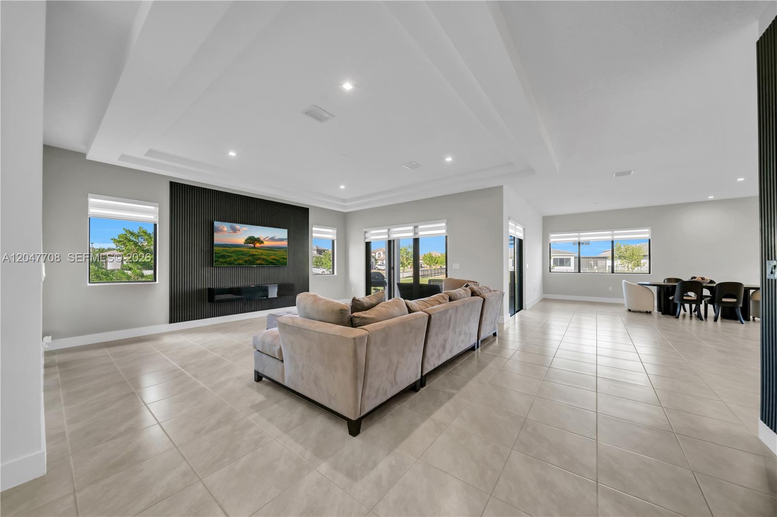 A living room features a large sectional sofa, a black slatted accent wall, and tile flooring — 5206 Karlia Dr, Ave Maria FL 34142, AVE MARIA, FL