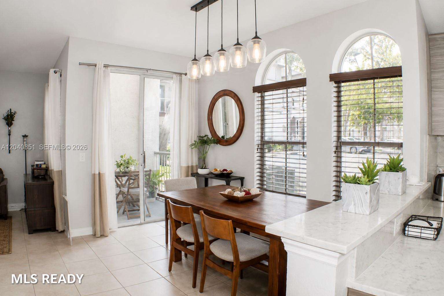A dining area features a wooden table, pendant lighting, and large arched windows — 4301 SW 160th Ave # 101, Miramar FL 33027, MIRAMAR, FL