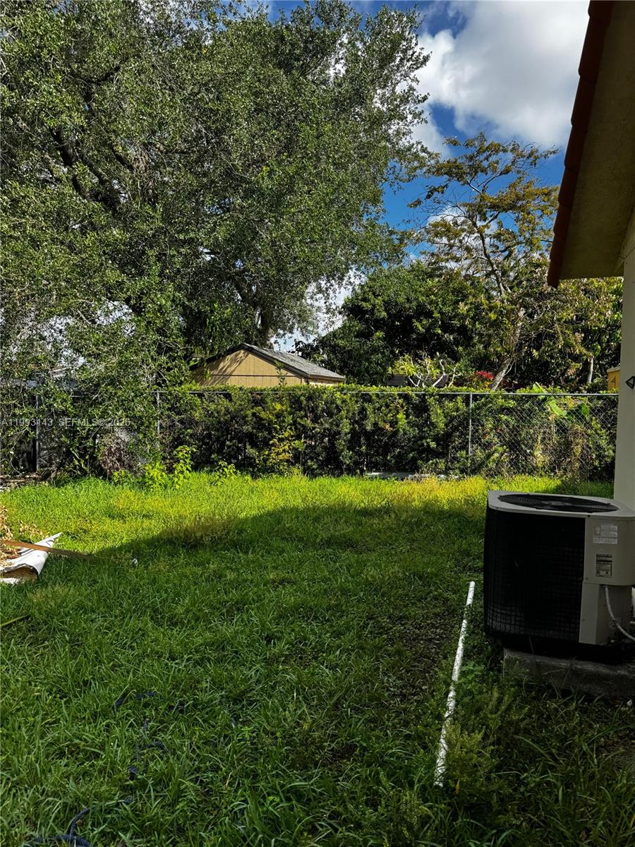 A grassy backyard features a chain-link fence, a small shed, and an outdoor air conditioner — 2194 SW 57th Ct # 2194, Miami FL 33155, MIAMI, FL