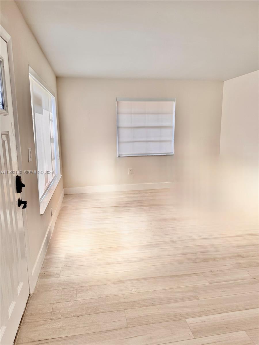 An empty room features light-colored wood-look flooring, white walls, and a window with blinds — 2194 SW 57th Ct # 2194, Miami FL 33155, MIAMI, FL