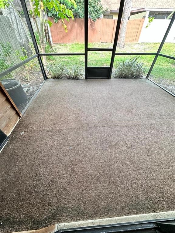 A screened-in porch features brown outdoor carpeting and views of a grassy backyard — 505 BRISTOL DRIVE, ALTAMONTE SPRINGS, FL