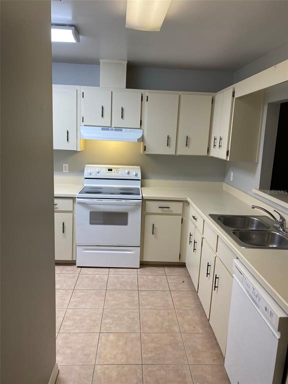 A kitchen features white cabinets, light-colored countertops, a white stove, and tiled flooring — 505 BRISTOL DRIVE, ALTAMONTE SPRINGS, FL
