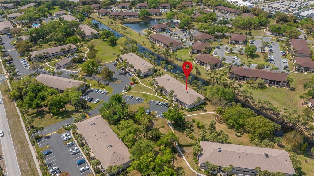 An aerial view shows multiple multi-story apartment buildings surrounded by parking lots and green landscaping — 1515 FORREST NELSON BOULEVARD UNIT L105, PORT CHARLOTTE, FL